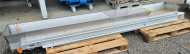 300 x 2950 mm. Aluminium/stainless steel with 150 mm sides. Food-grade quality. Small inspection windows and discharge trays at both ends for removing debris. Drum motor.
